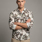 Full length view of model wearing the botanical leaf print shirt and khaki pants
