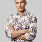 Close-up of model with arms crossed wearing Showane purple floral shirt