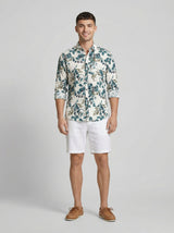 Front full view of a man wearing a Men's Botanical Print Crinkle-Texture Long Sleeve Button-Down Shirt and white linen shorts.